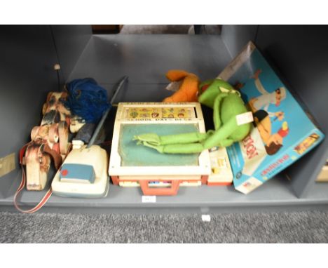 A shelf of mixed Toys, MB Games Operation, Fisher Price Kermit The Frog, School Days Desk, Snoopy and Pocket Camera, Jim Hens