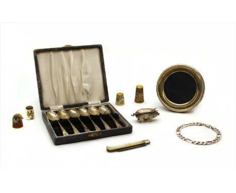 A collection of silver items, comprising a silver pig tape measure, with import marks for Birmingham, a silver photo frame, a