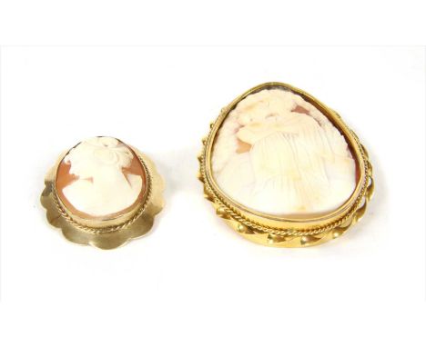 A gold mounted shell cameo brooch, depicting a couple, rub set to a twisted wire frame, with pin, 'C' catch and safety chain,