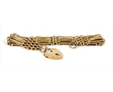 A gold five row gate bracelet, with alternating straight and bowed bars, to heart shaped padlock clasp, tested as approximate