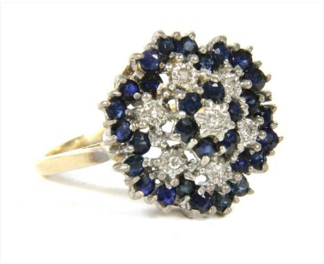 A 9ct gold diamond and sapphire four tier cluster ring, with stepped rows of eight cut diamonds and circular mixed cut sapphi