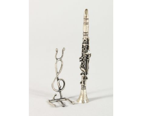 A MINIATURE SILVER CLARINET AND STAND.