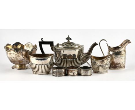 A matched three piece silver tea service with semi gadrooned decoration, an Edwardian silver jug, a silver octagonal footed b