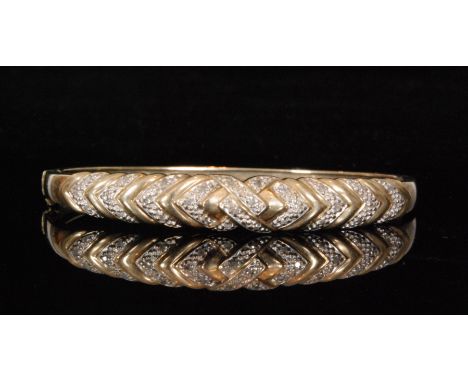 A modern 9ct and diamond hinged bangle of interlinked wishbone design, weight 13g.  