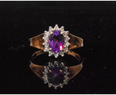 A 9ct amethyst and diamond cluster ring, central oval claw set amethyst within a fourteen stone brilliant cut diamond surroun