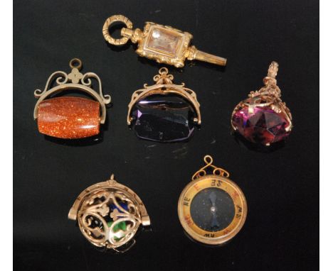 Four 9ct fobs, to include a pierced ball containing three coloured dice, two with facet cut purple stones, a circular compass