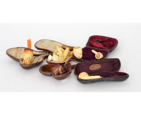 A 19th Century meerschaum pipe modelled as a lady's hand with amber stem, S/D, together with as an eagle's claw holding a bow