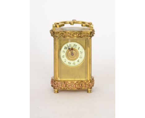 A 19th Century French brass carriage clock with Arabic dial enclosed by a bevelled glass panel below and above bands of scrol