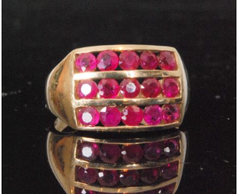 A modern 9ct hallmarked ruby ring comprising of three rows of five channel set rubies to plain tapering shoulders, ring size 