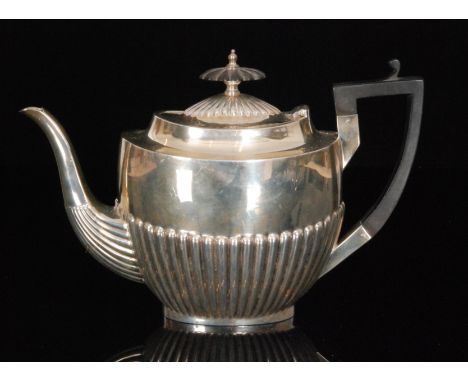 A hallmarked silver boat shaped teapot with part fluted decoration terminating in ebonised handle, weight 19oz, Sheffield 192