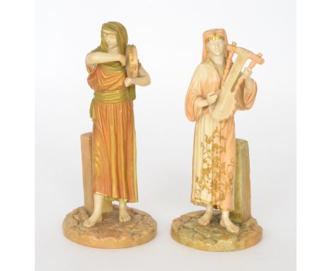 A matched pair of late 19th Century Royal Worcester Hadley figurines modelled as Eastern Musicians in the Egyptian Revival ta