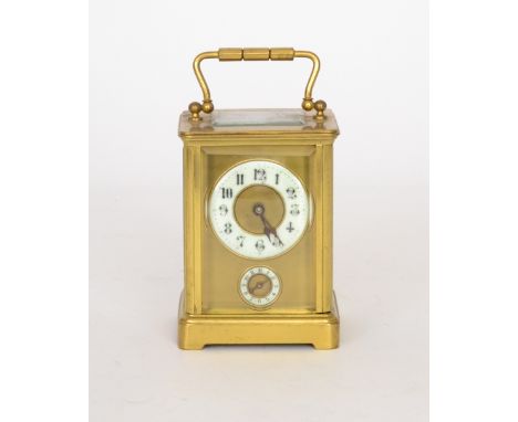 An early 20th Century French brass carriage clock with circular Arabic dial and subsidiary dial to a matted centre on bracket