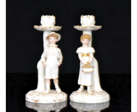 A pair of Royal Worcester candlesticks modelled by James Hadley depicting a young girl dressed in bonnet and carrying a baske