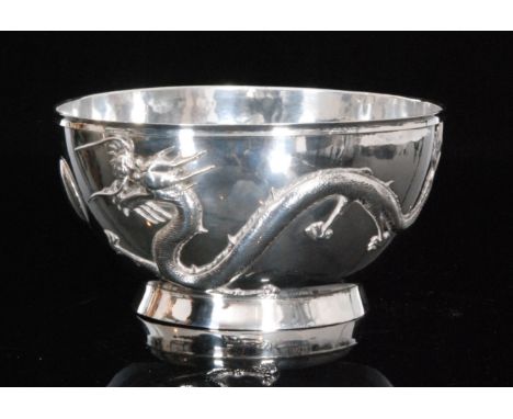 A Chinese silver rose bowl with cast decoration of two scrolling dragons chasing a pearl on circular foot, character mark to 