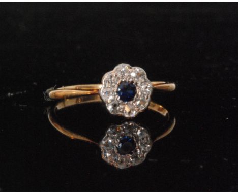 An early 20th Century 18ct sapphire and diamond daisy cluster ring, central sapphire within eight stone old cut diamond surro