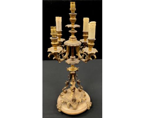 A gilt metal five light table lamp, as a candelabra, with central taller light, surrounded by four floral scrolling arms, tri