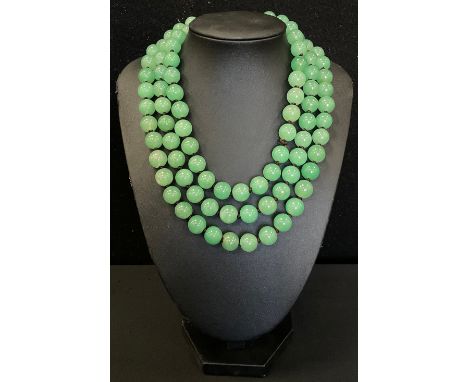 A string of green jade effect beads, 68cm long 