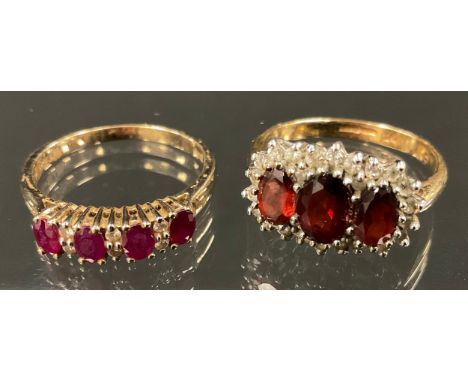 A ruby and diamond ring, linear set with four oval red rubies divided by pairs of diamond accents, 9ct gold shank, size R, 2.