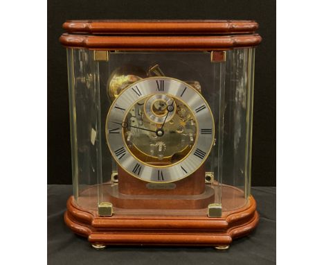 A Franz Hermle part skeleton dial mantel clock, model number number 352-070, the shaped glass case enclosing a circular chapt