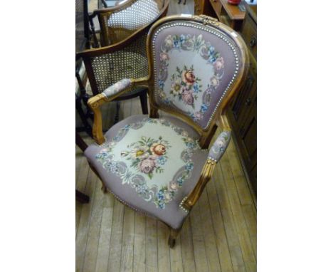 A reproduction Louis XV style armchair, upholstered in a tapestry floral material.