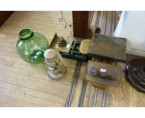 A vintage metal framed oil lamp, together with a large green glass jar and two sets of balance scales with assorted weights.