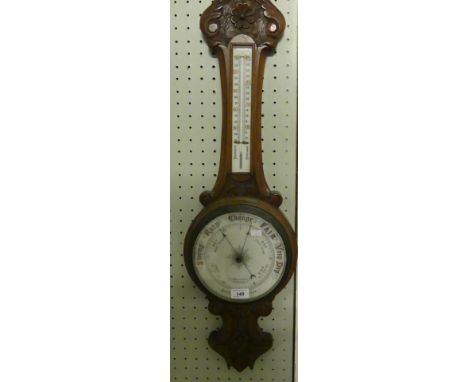 A late 19th/early 20th Century barometer/thermometer, in carved cased bearing retailers marks for Thomas Wallace & Co, Holbor