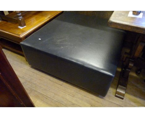 A modern black leatherette pouffe of square proportions.