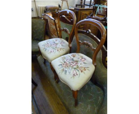 A pair of tapestry seated Victorian mahogany balloon back chairs raised on cabriole legs.