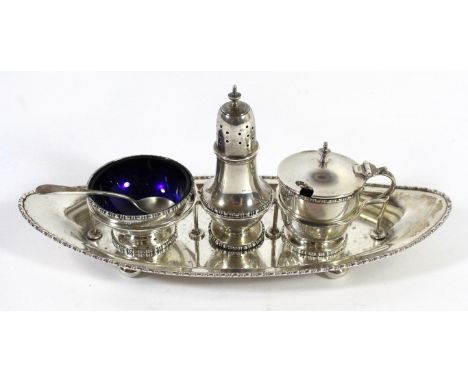 A George V silver condiment setThe navette shape tray with bun feet encasing a silver shaker together with a silver mustard p