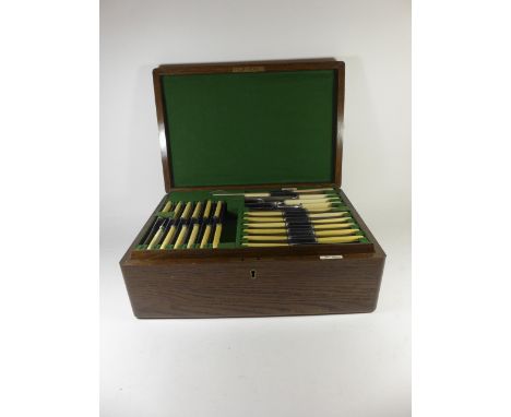 An early 20th century oak canteen of silver plated and steel cutlery By Walker & Hall plus others, the hinged box fitted with