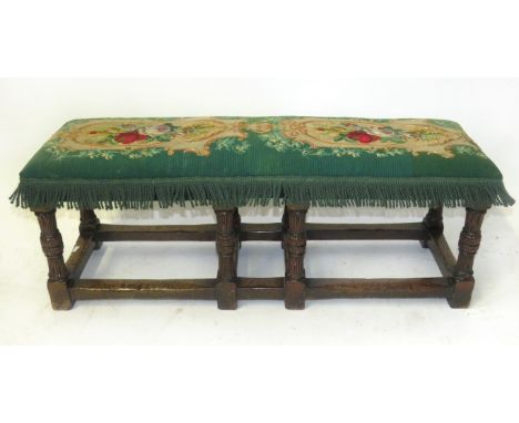 An oak tapestry covered footstoolThe base modelled in the 17th Century style, height 36cm, width 92cm, depth 27cm 