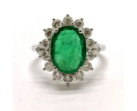 18ct marked white gold emerald (approx 11.5mm x 8.5mm) &amp; diamond cluster ring with diamond trapezium type cut shoulders (