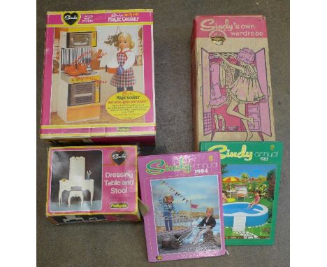 Three Sindy items of furniture, dressing table and stool, wardrobe and magic cooker, plus two annuals