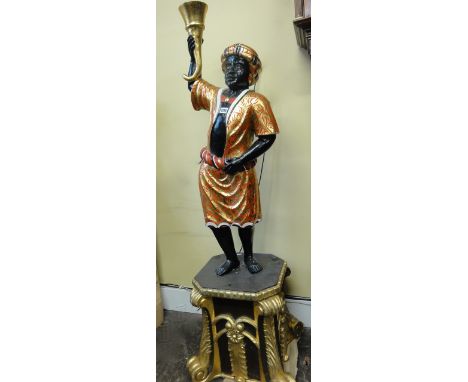 A lamp standard in the form of a character in a gilt and red scrolled costume holding aloft a cornucopia raised on a square c