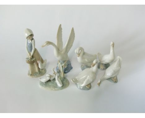 A collection of Lladro Daisa Nao figures including a girl carrying a basket of chicks accompanied by a hen, a swan with outst