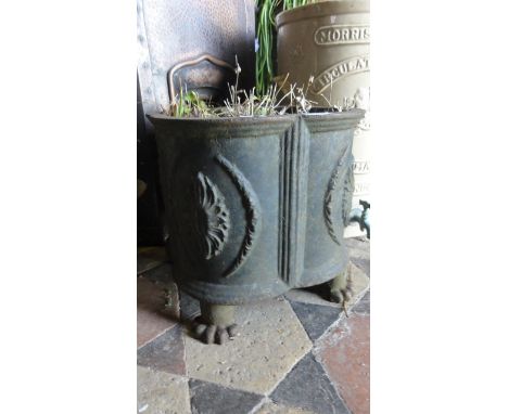 A small cast iron planter of squat quatrefoil form with foliate detail and paw feet.