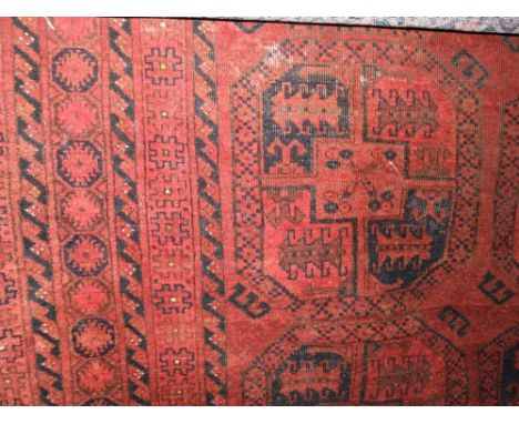 A red ground Afghan wool carpet with multi-medallion centre upon a red ground within running borders, 330 x 210 cm