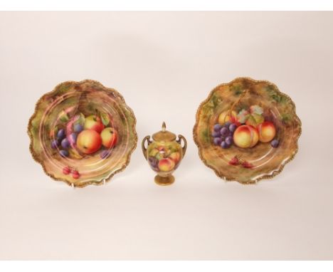 A pair of Royal Worcester cabinet plates with shaped borders and painted fruit detail including raspberries, peaches and grap