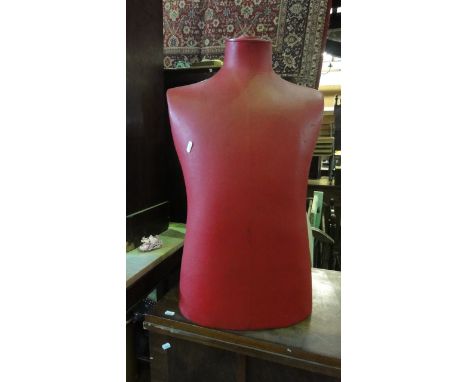 A vintage male mannequin torso stamped Stockman, 22 Dering Street, London W1, in a red colourway