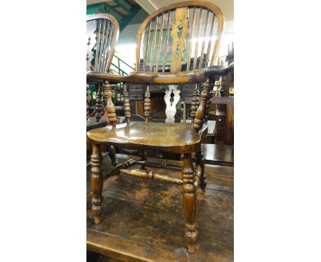 A Georgian Windsor comb back elbow chair, principally in elm and ash, with shaped and pierced splats, scrolled arms and turne