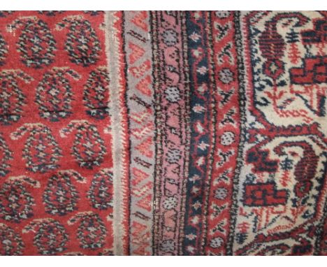 A very substantial Eastern style wool carpet with a red field, geometric detail and set within deep running borders, 4.5 metr