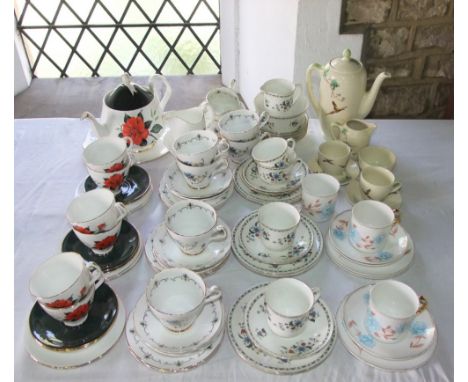 A small collection of Shelley coffee cans and saucers with painted blue rose decoration comprising three cups, three saucers 