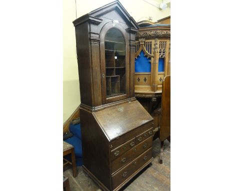 A small 18th century oak bureau bookcase, the bureau fitted with two long and two short drawers, the fall flap enclosing a fi