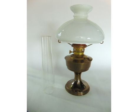 A brass oil lamp with opaline glass shade.