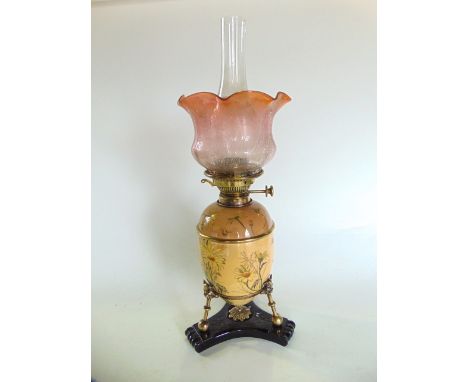 A late 19th century Aesthetic movement ceramic oil lamp and decorated glass shade, the ovoid shaped fount and base are transf