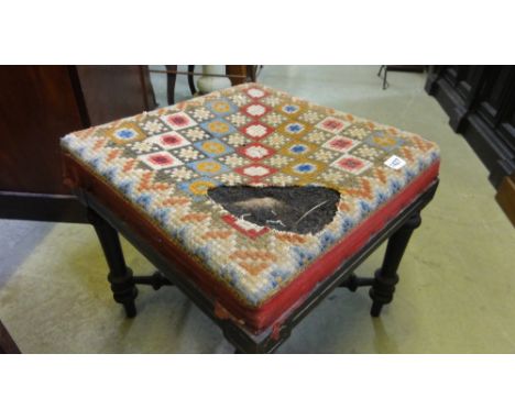 A Victorian ebonised stool, the square upholstered seat (AF) raised on four turned supports united by a further turned X fram