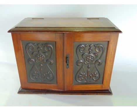 An Art Nouveau oak and copper smokers cabinet