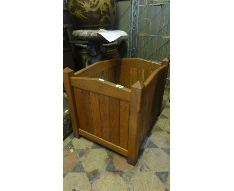 A good quality contemporary oak planter of rectangular form with slatted panelled frame and chamfered supports with faceted p