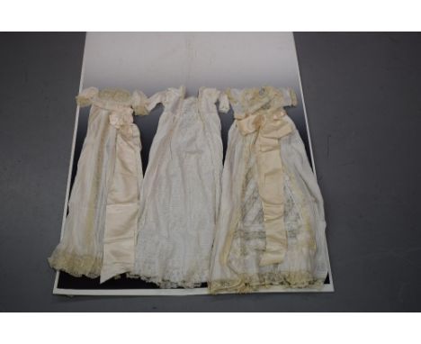 Three christening gowns, two fine lawn with pin tucks and lace inserts with satin ribbon sashes; the third in fine white cott