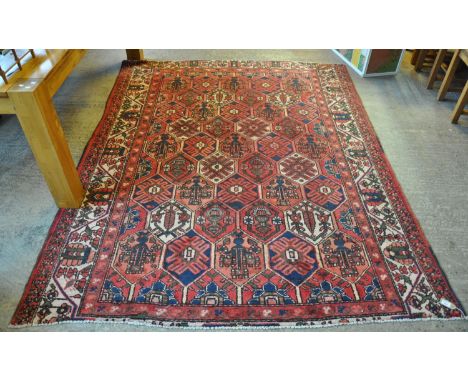 Vintage washed red ground Persian Baktia carpet with Persian panel design. 268 x 205cm approx. (B.P. 21% + VAT) Some wear and